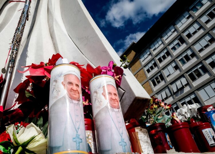 ROME (Italy), 21/02/2025.- Candles with the pictures of Pope Francis and flowers lay at the foot of a statue of Pope St. John Paul II outside Gemelli University Hospital, where Pope Francis is hospitalized for bronchitis treatment, in Rome, Italy, 21 February 2025. Pope Francis was hospitalized on 14 February due to a respiratory tract infection. (Papa, Italia, Roma) EFE/EPA/GIUSEPPE LAMI