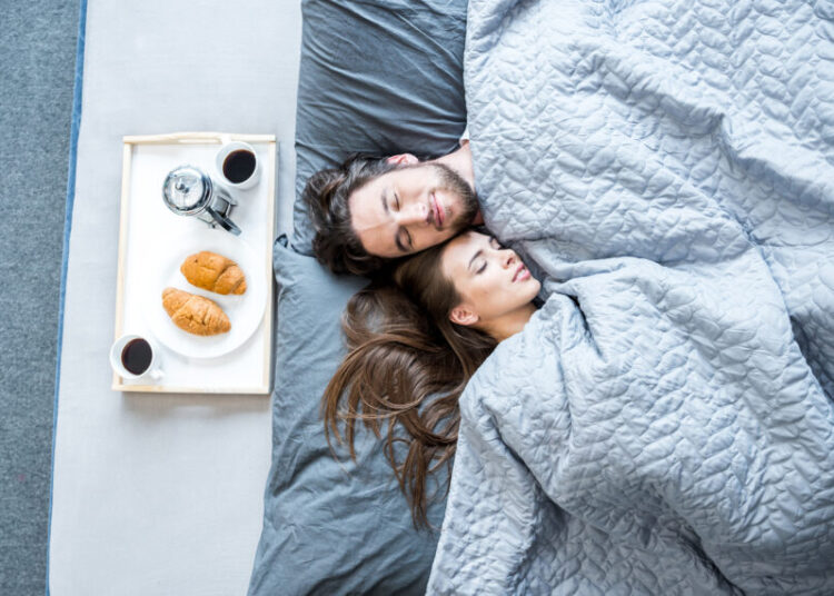 Top view of young man and woman sleeping in bed