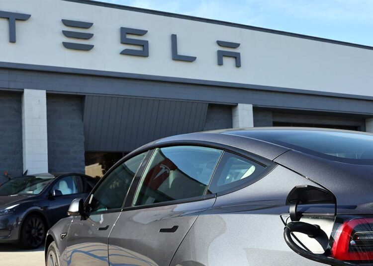 BURBANK, CALIFORNIA - JANUARY 16: A Tesla electric car recharges at a Tesla dealership on January 16, 2024 in Burbank, California. Carbon emissions fell by about 1.9 percent in 2023, a positive signal, but further cuts must be implemented if the U.S. hopes to achieve its climate goal of 50 percent emissions cuts by 2030.   Mario Tama/Getty Images/AFP (Photo by MARIO TAMA / GETTY IMAGES NORTH AMERICA / Getty Images via AFP)